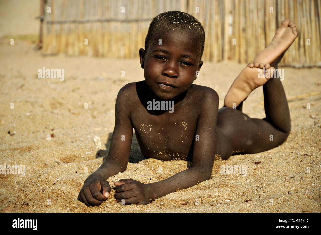 Bare boy lying on his belly on the beach in village of Chembe, Cape  Maclear, Malawi Stock Photo - Alamy
