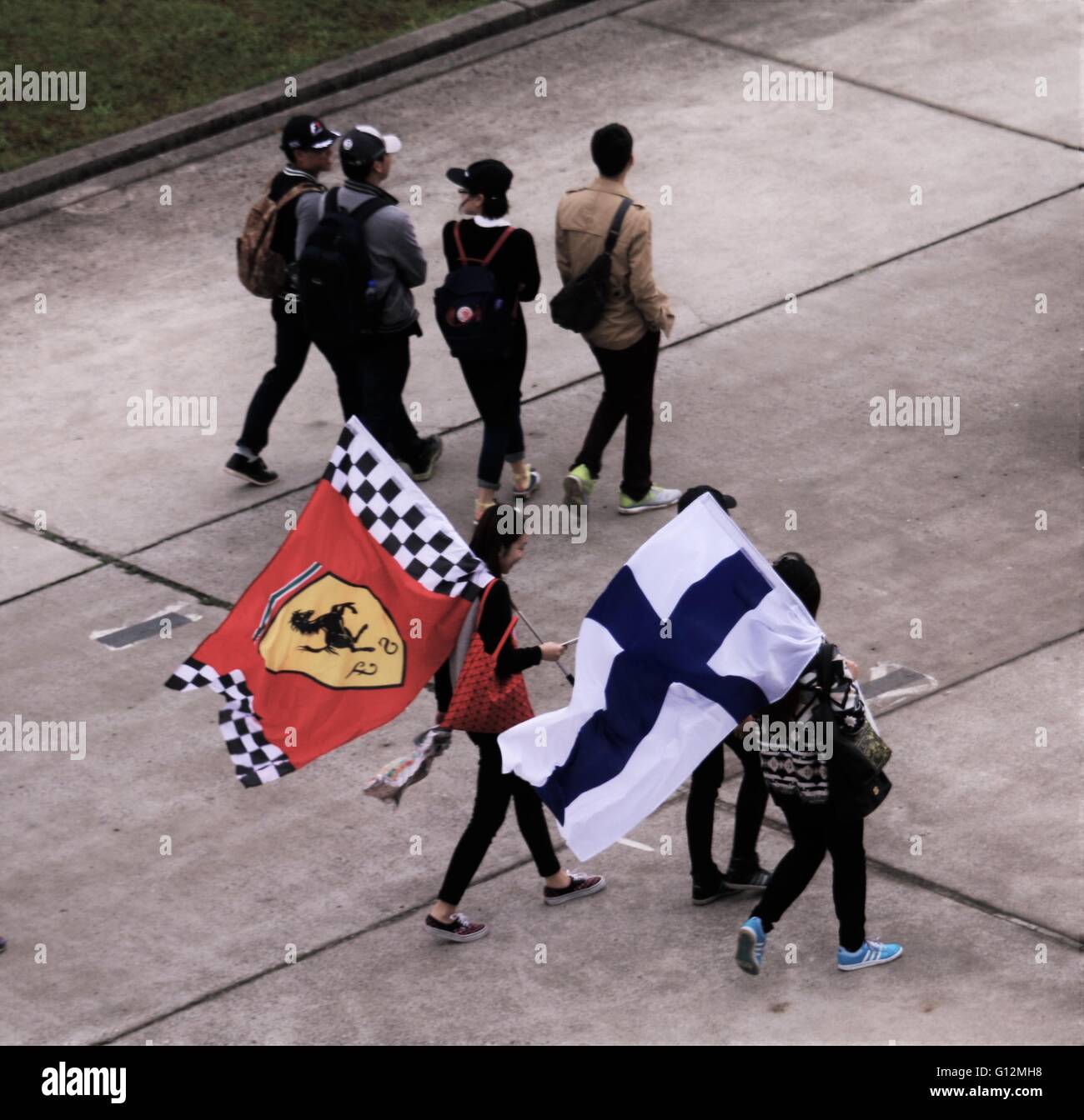 Chinese fans carrying Ferrari and Finnish flags at the Shanghai formula one 2016. Stock Photo