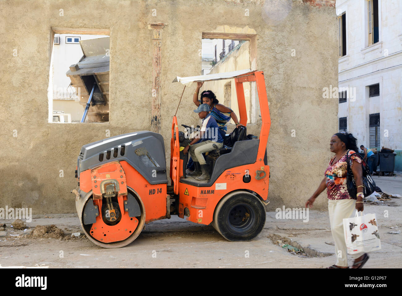 A mother teaches her young son how to drive a road roller in Central Havana, Havana, Cuba Stock