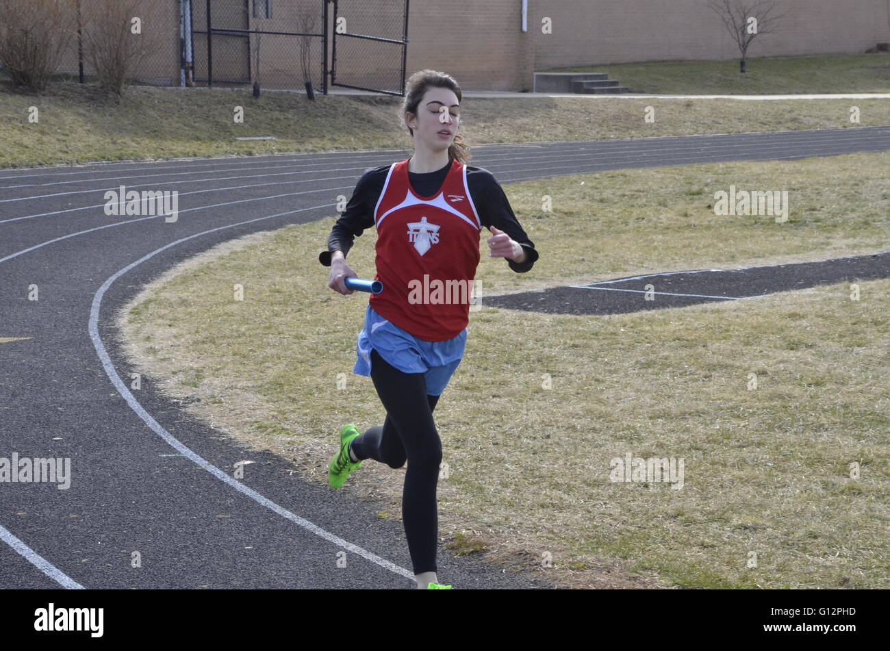 Runner in relay race in a track meet Stock Photo