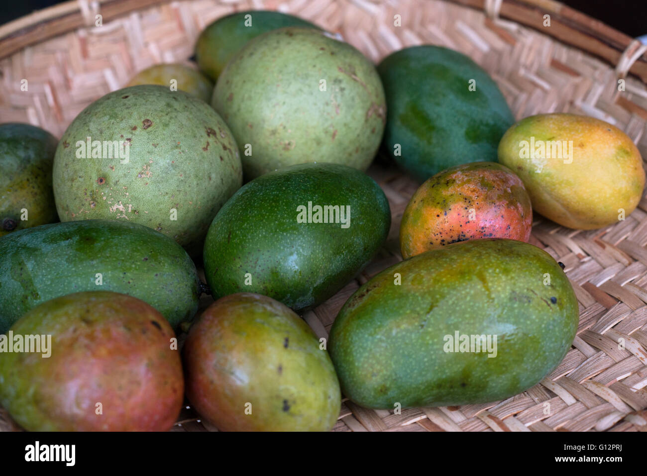 Different sorts of srilankan mangos in straw basket Stock Photo