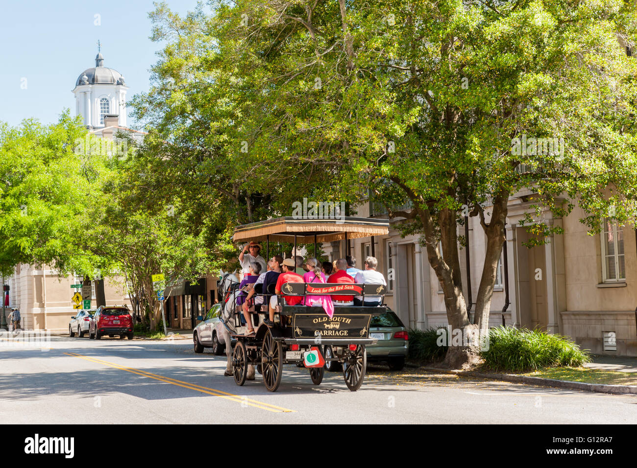 Tourists take a horse-drawn carriage tour on E Bay Street in historic Charleston, South Carolina. Stock Photo
