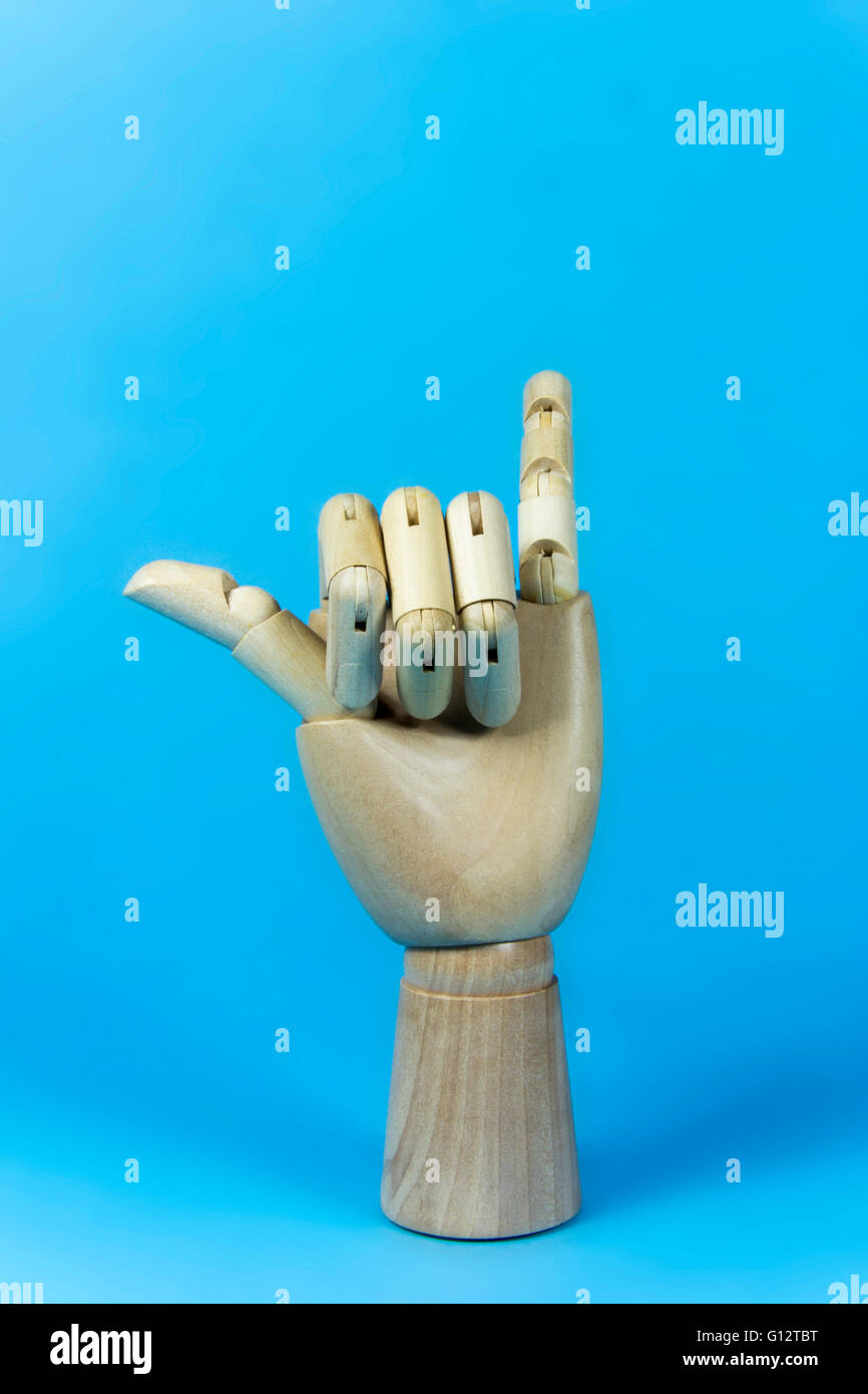 hand wood, wooden hand, hang loose fingers, blue background Stock Photo