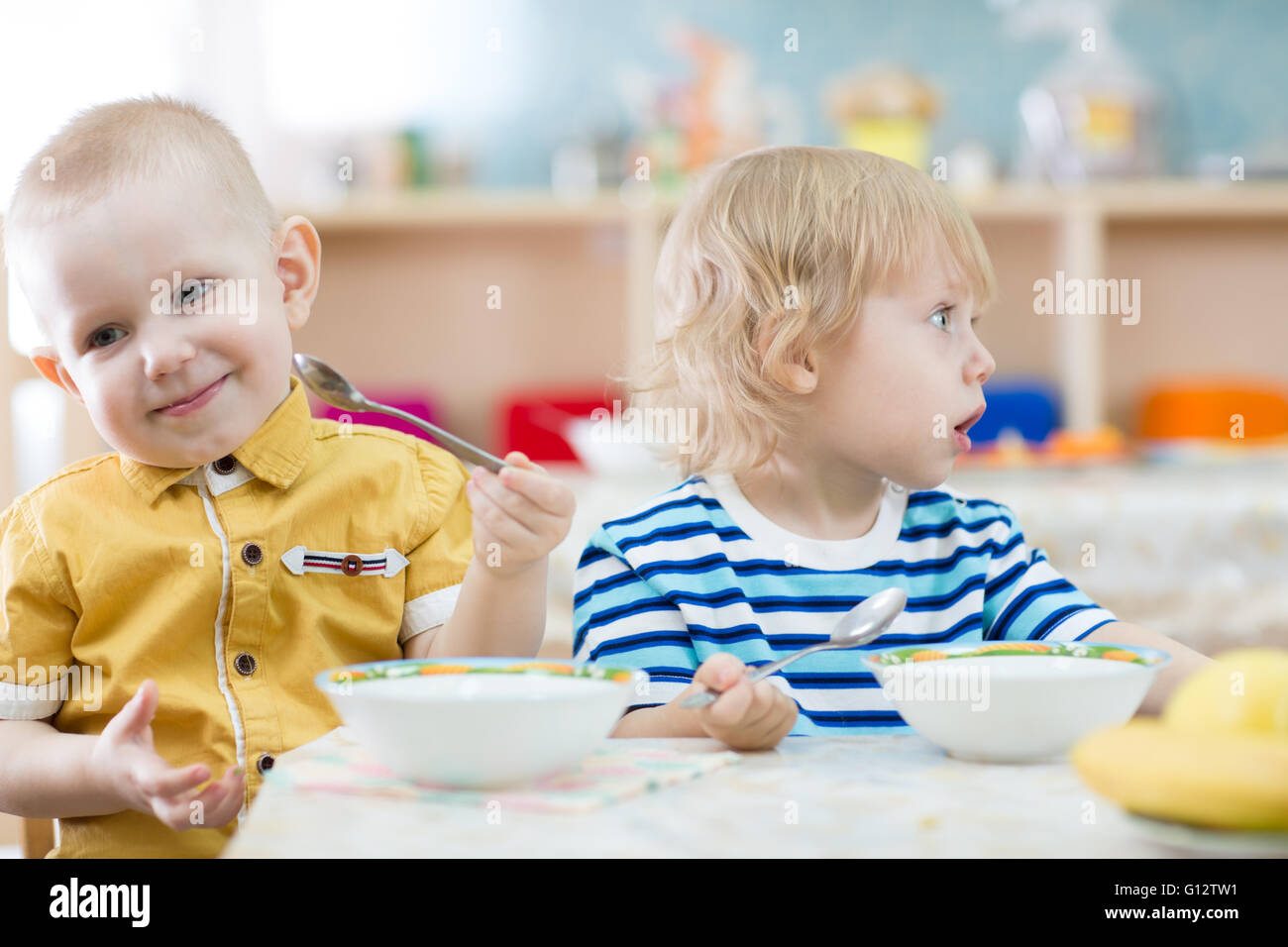 Funny children eating in kindergarten Stock Photo