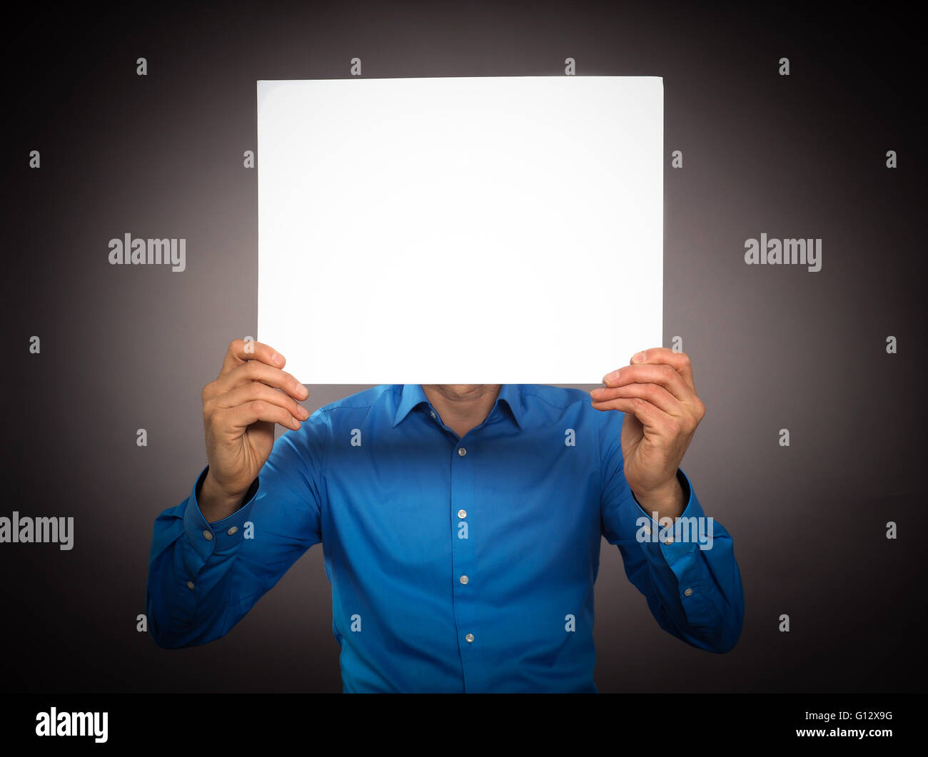 Business man holding a white sign in front of his face Stock Photo