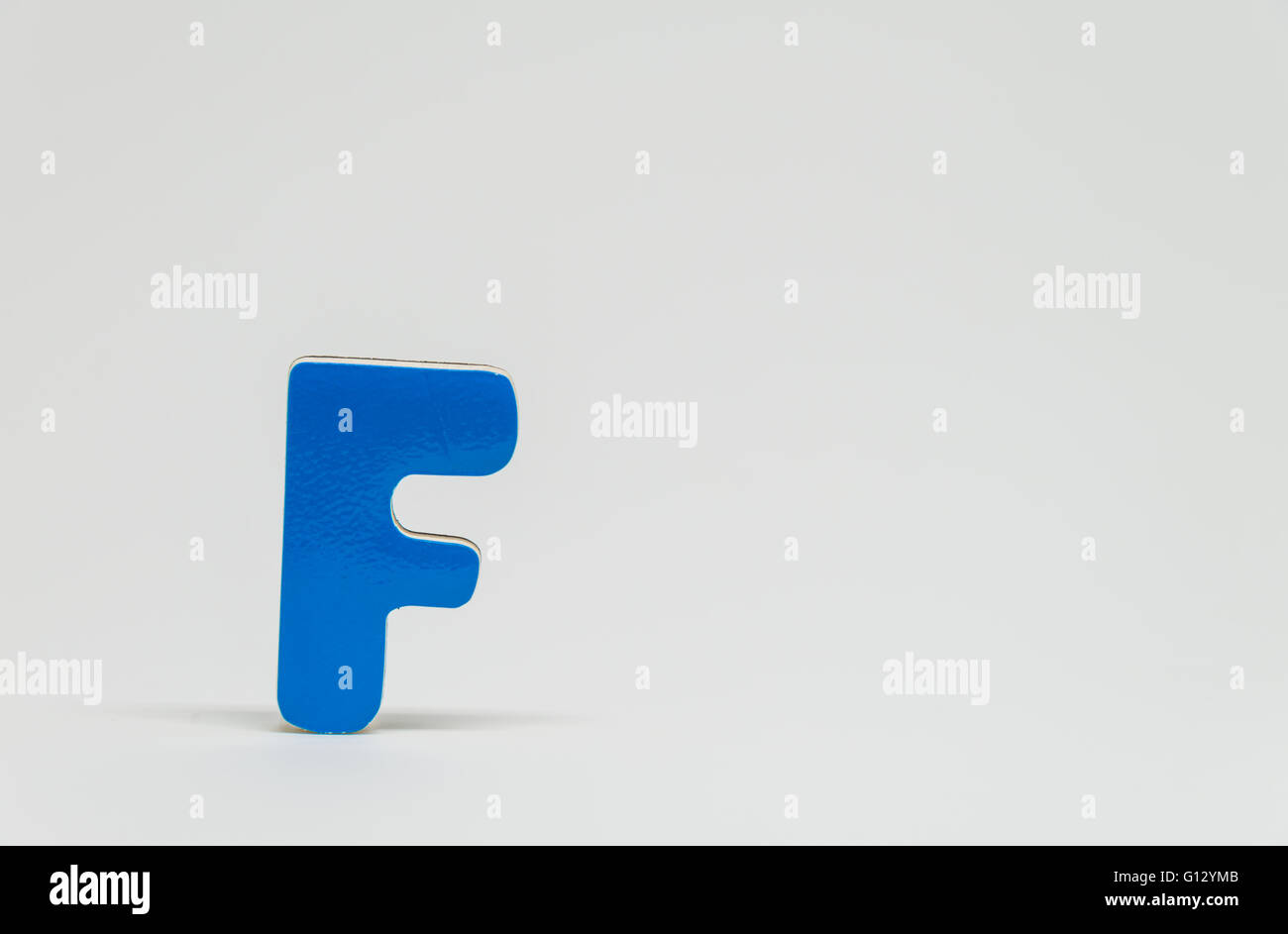 Blue wooden alphabet F with white background and selective focus Stock ...