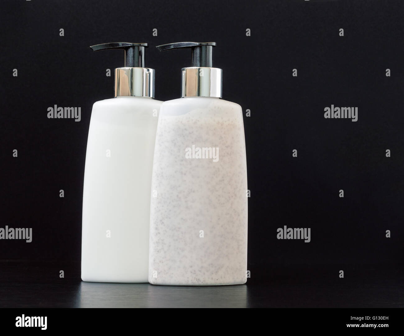 Skin exfoliation cream and makeup remover lotion in pump plastic bottles on a dark table Stock