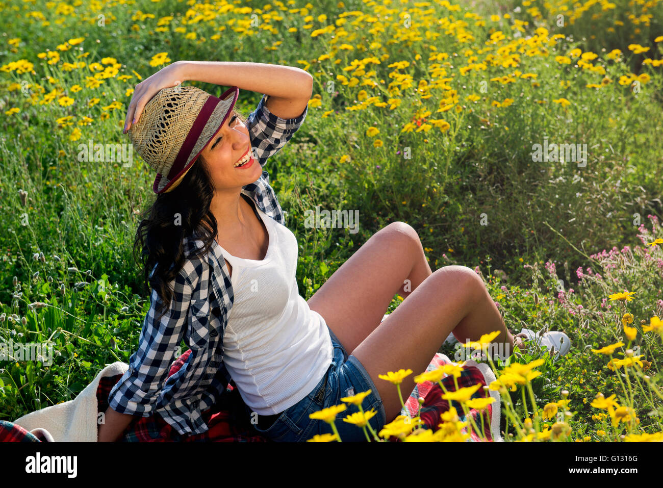 beautiful long-haired woman with straw hat sitting in a field Stock ...