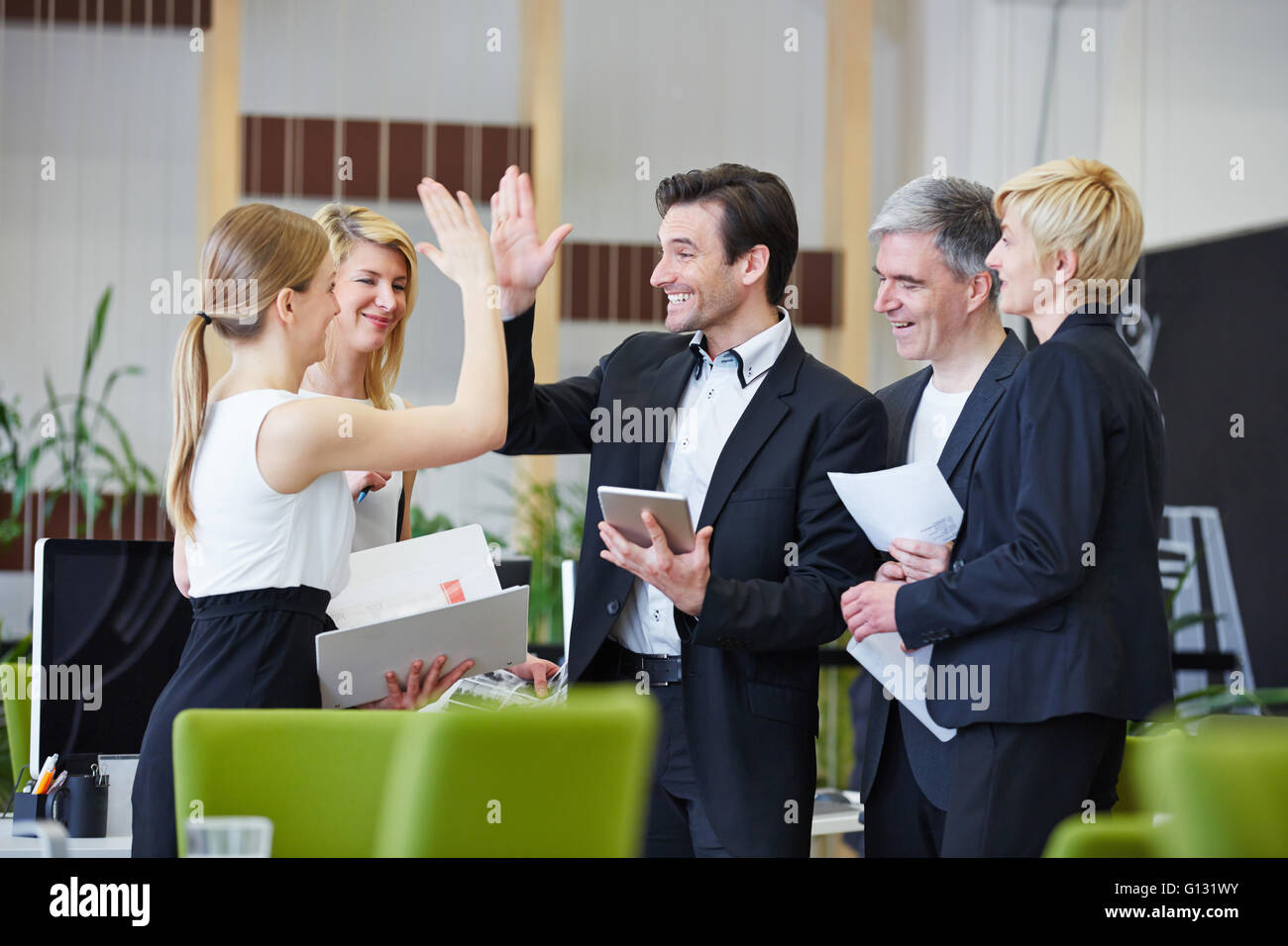 Successful team of business people giving high five in the office Stock ...