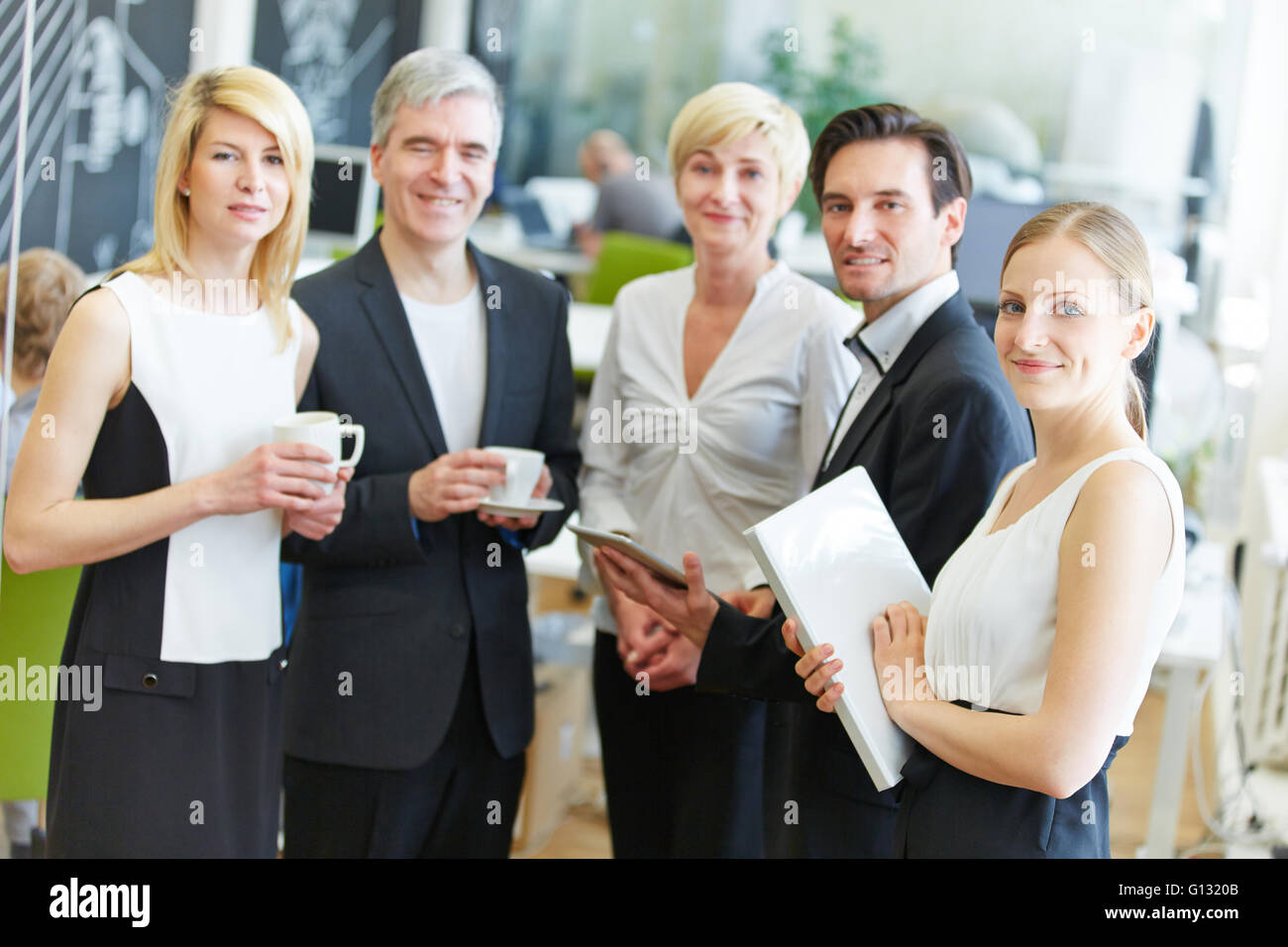Group of happy business people standing in the office Stock Photo - Alamy