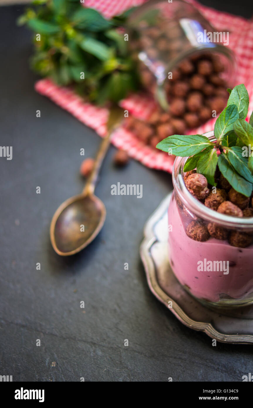 Chocolate breakast flakes with yogurt and mint in vintage glass on ...