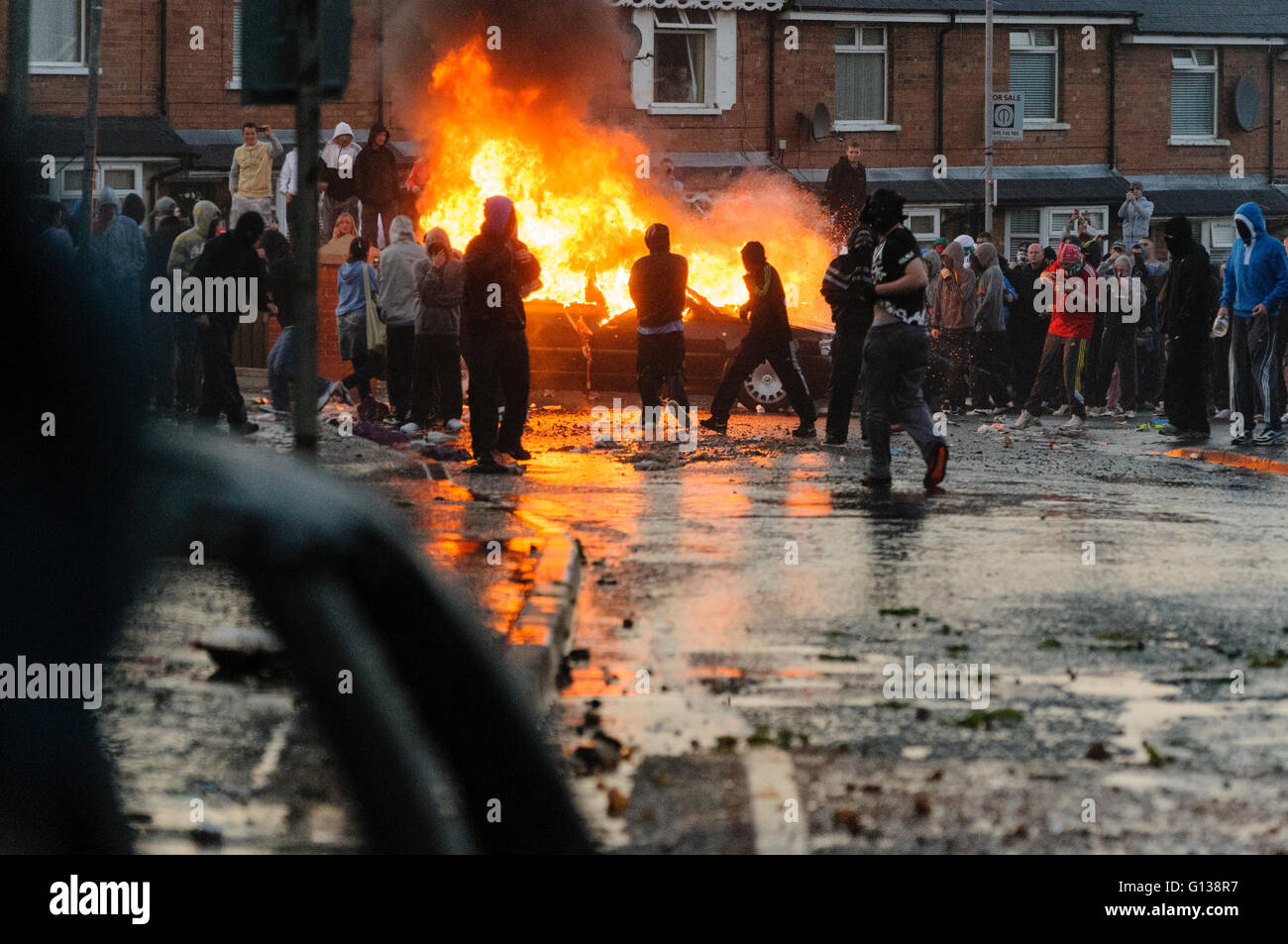 Belfast, Northern Ireland. 12 Jul 2011 - Nationalist youths from Ardoyne hikack and set fire to a car during a riot, after the annual Twelth of July parade, celebrating the Battle of the Boyne in 1690 was allowed to pass along the main Crumlin Road Stock Photo