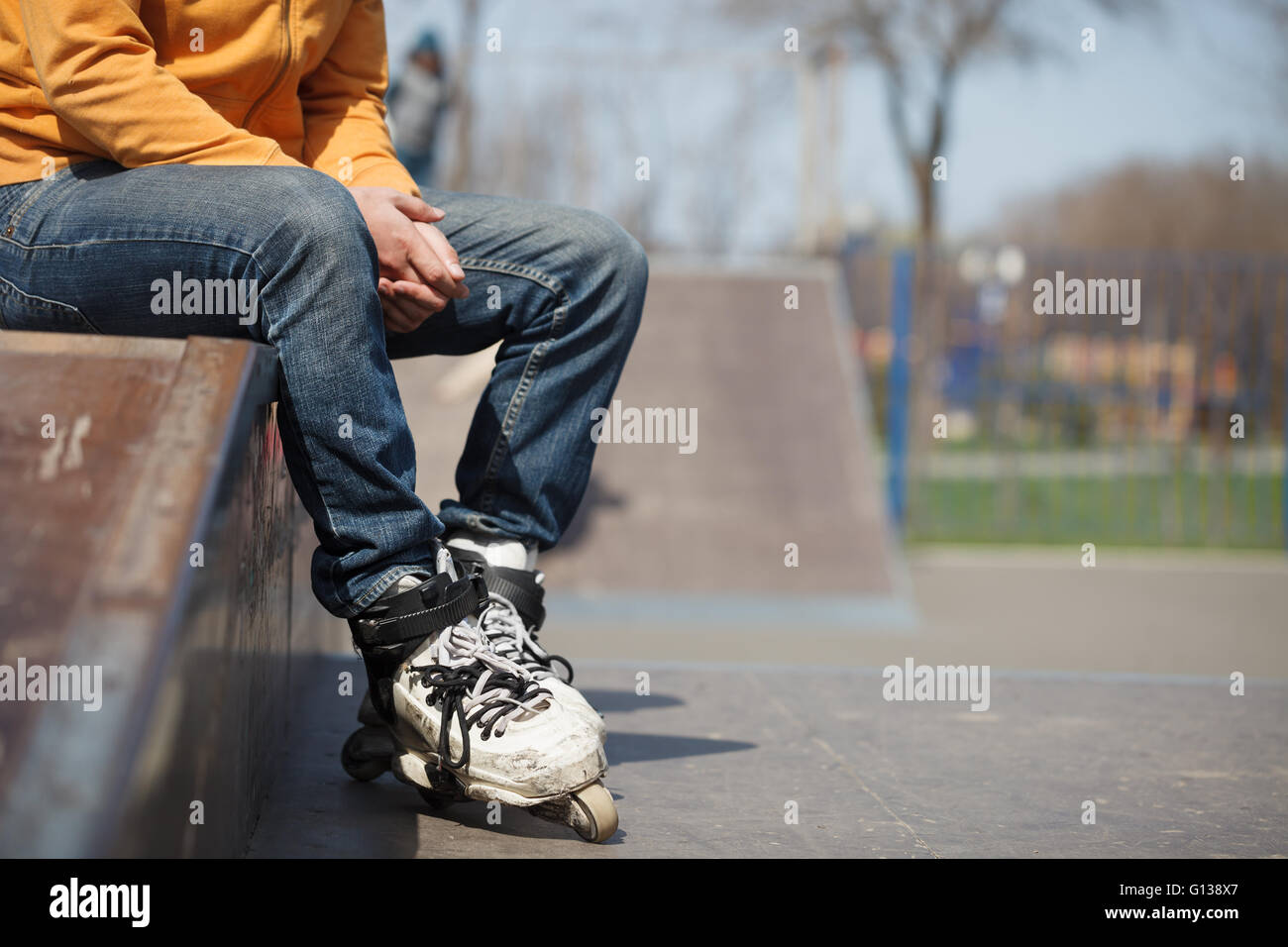 Rollerblader sitting in skatepark wearing professional extreme inline