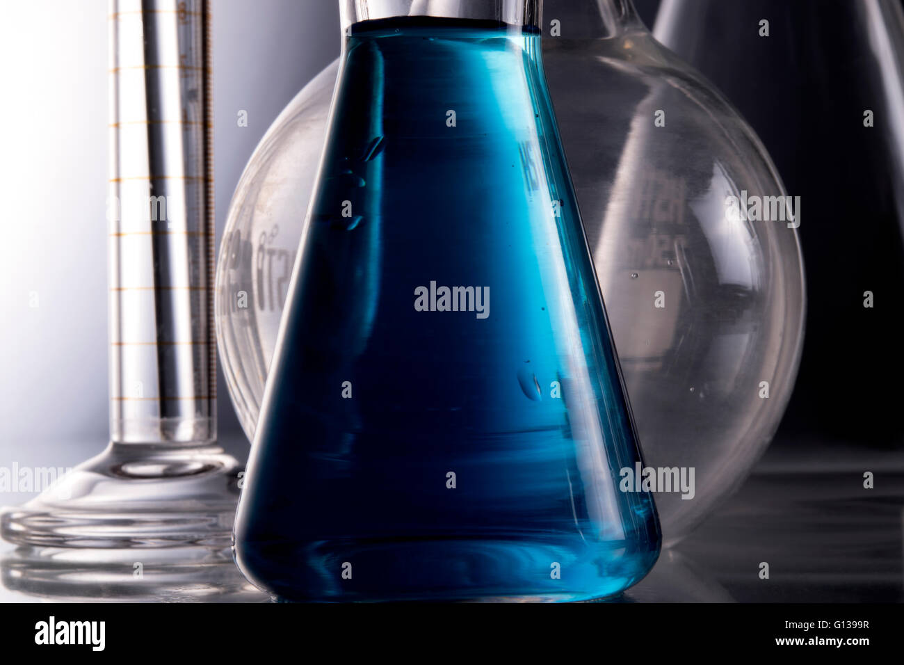 Blue chemistry in Erlenmeyer flask, boiling flask, funnel, with