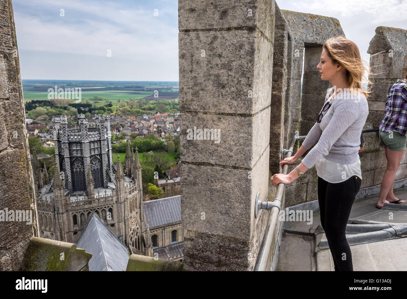 A beautiful girl catches the wind in her hair high atop the Ely cathedral on a sunny sun sunshine day in May 2016 Stock Photo