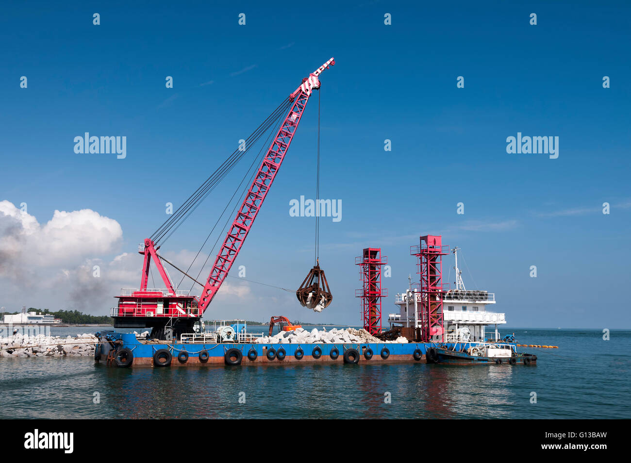 Industrial floating sea crane for carrying the rocks and stones Stock Photo