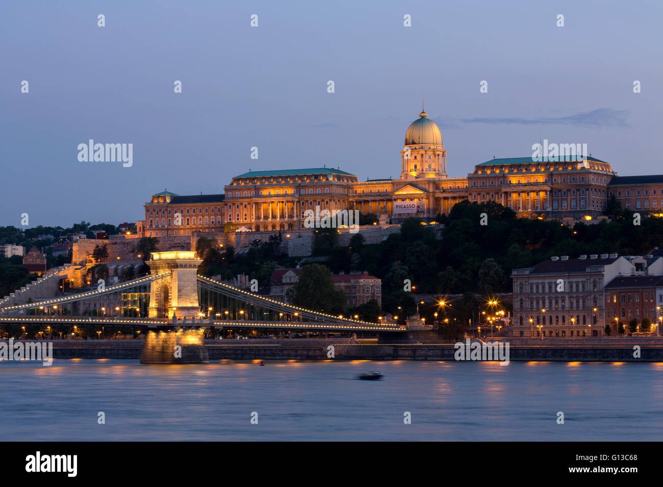 View of Chain Bridge and Castle Hill with National Gallery during Picasso exhibition in Budapest at dusk Stock Photo