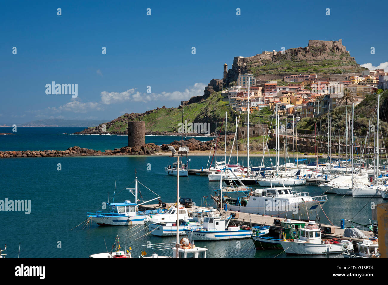 Castelsardo,Sassari,Sardinia, Italy, 10/4/2016. View of boats at moor on the port, the old tower and the colored old town. Stock Photo