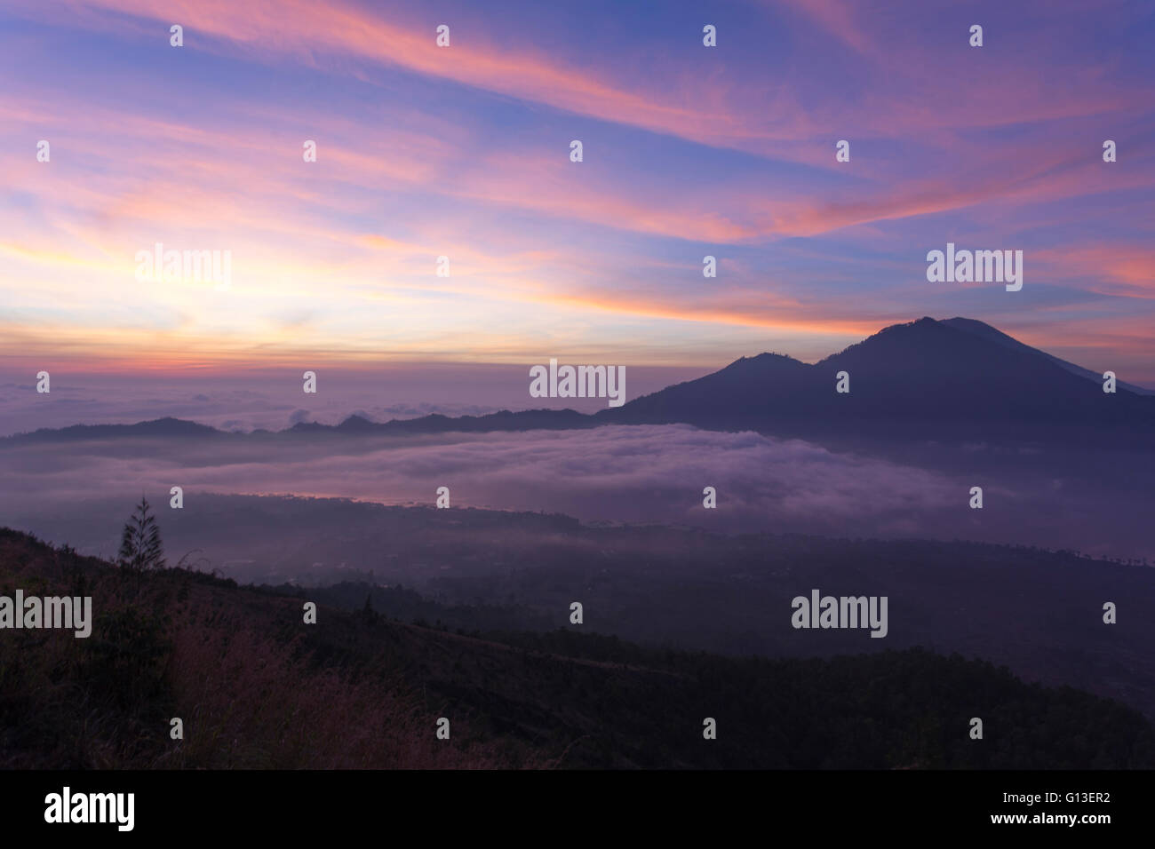 Sunrise above clouds with a mountain volcano view Mt Batur Bali ...