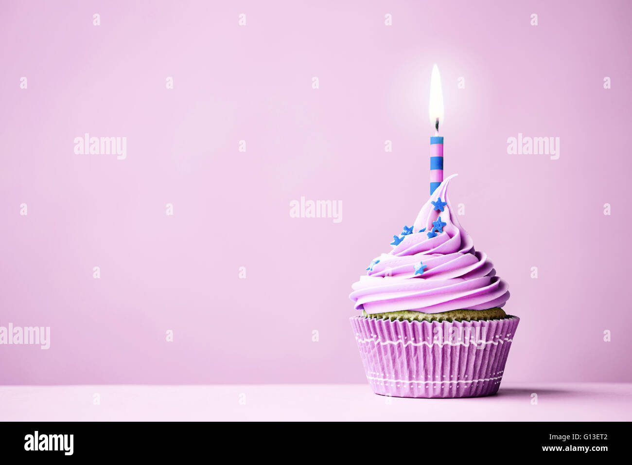 Purple birthday cupcake with copy space to side Stock Photo