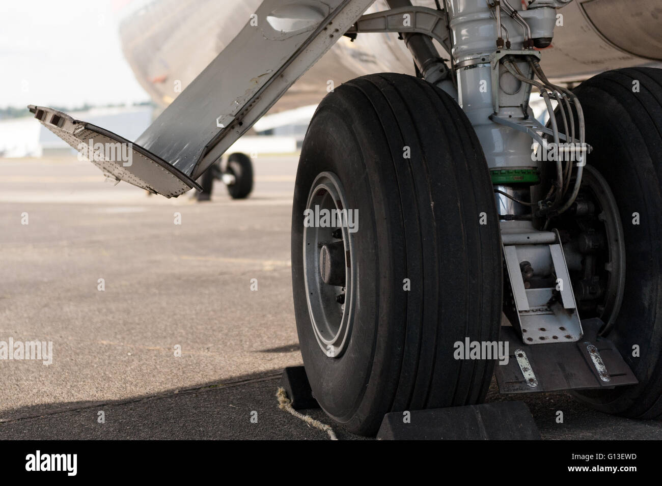 Transport aircraft main landing gear closeup showing tires, gear door