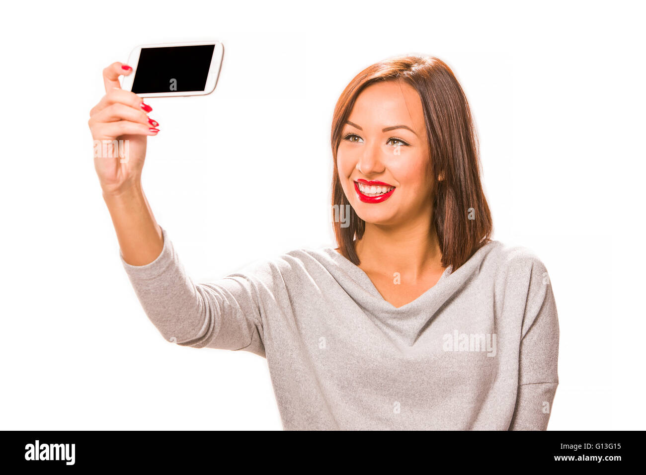 Beautiful happy young woman taking selfie using smartphone. Stock Photo