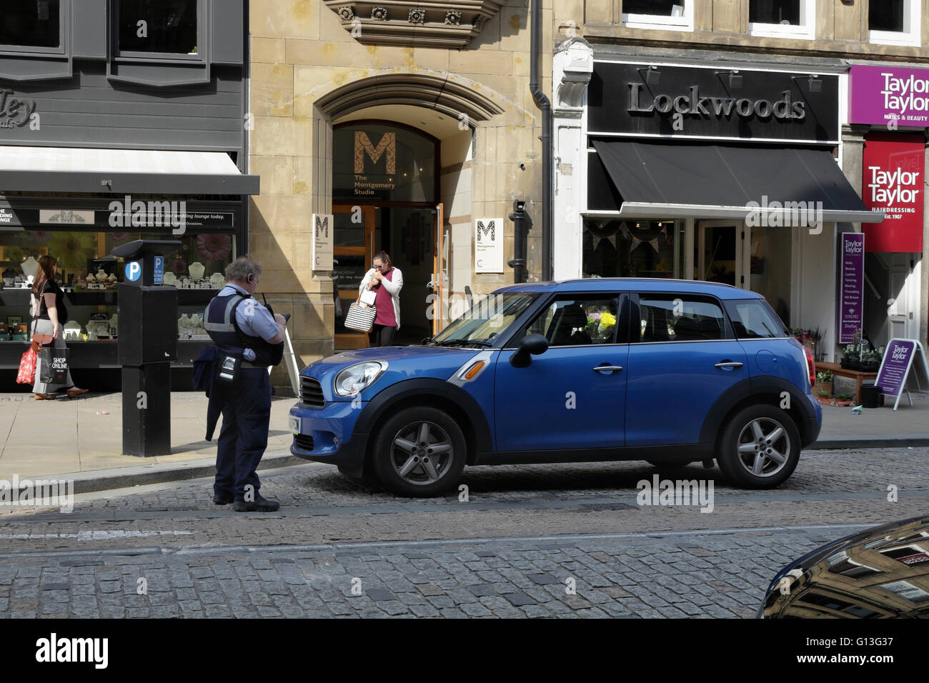 Traffic warden about to issue a parking ticket, Sheffield city centre Stock Photo
