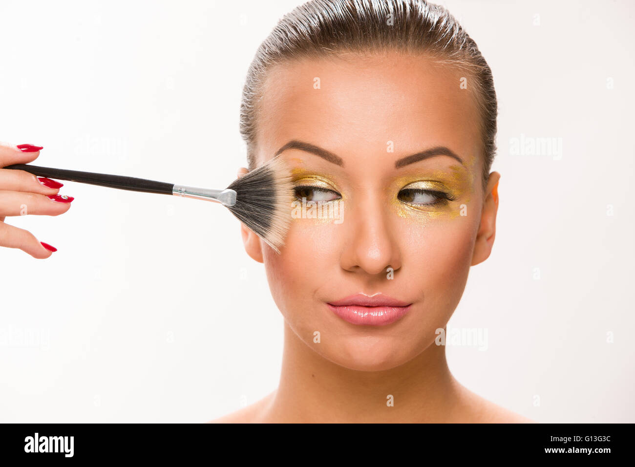 Make up. Brown sleek hair beautiful woman with fan brush close to face. Stock Photo