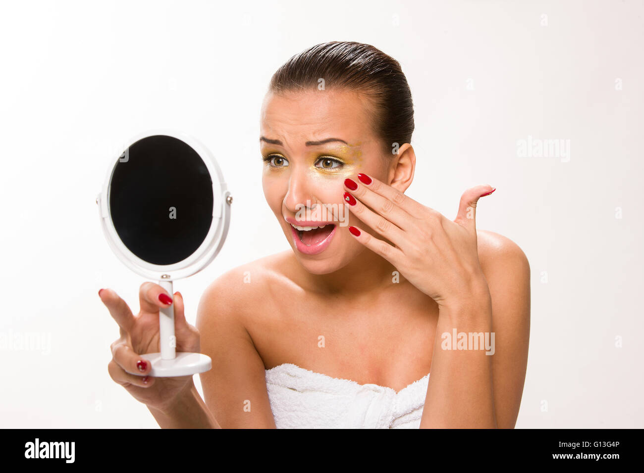 Gold make up. Brown sleek hair beautiful woman looking at mirror. Stock Photo