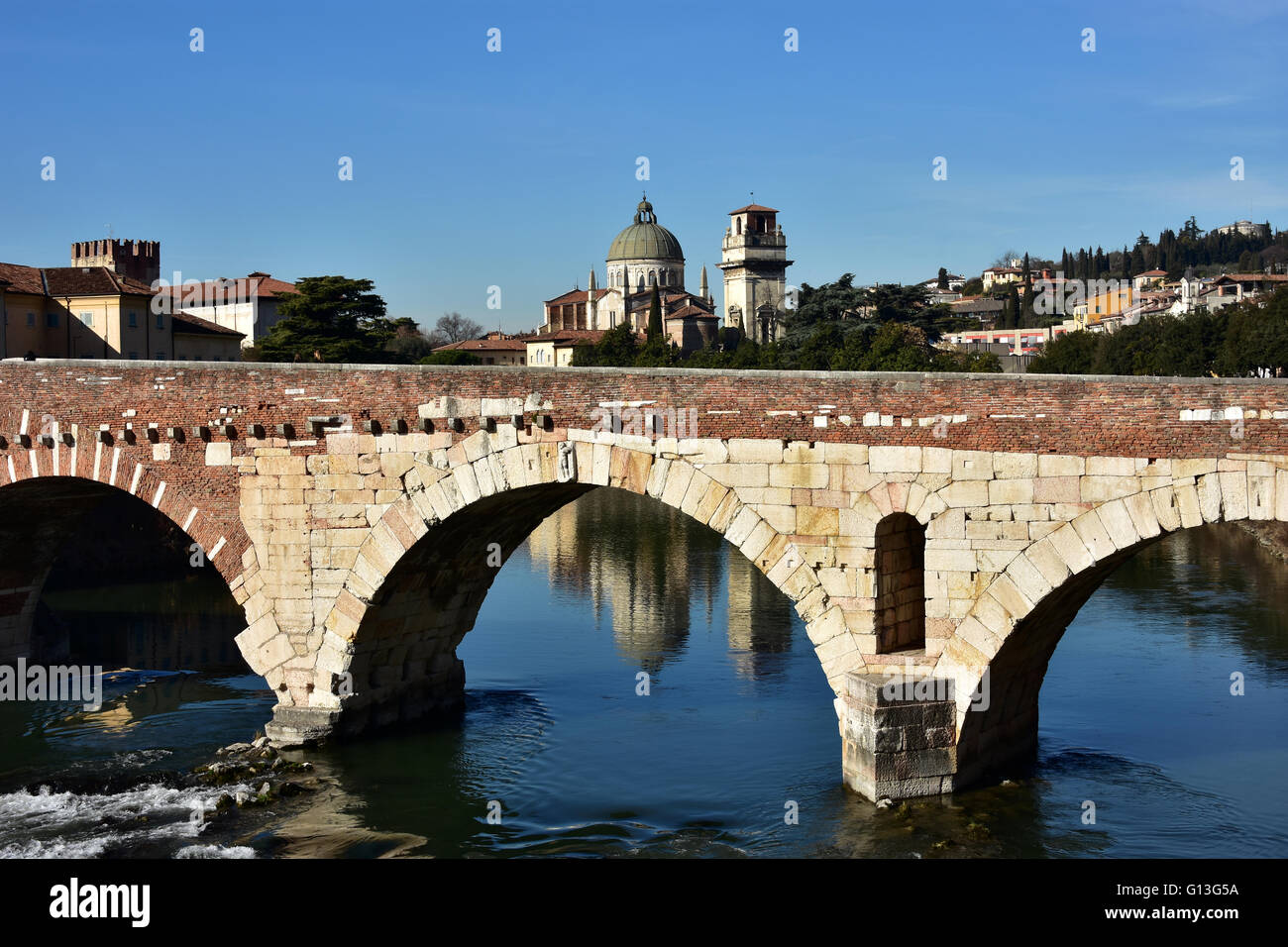 San Giorgio in Braida renaissance church reflection in Adige River behind ancient Ponte di Pietra (Stone Bridge) Stock Photo