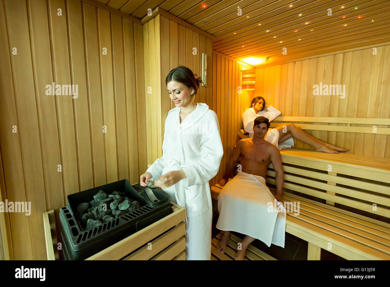 Woman pouring water on the rocks in the sauna Stock Photo Alamy