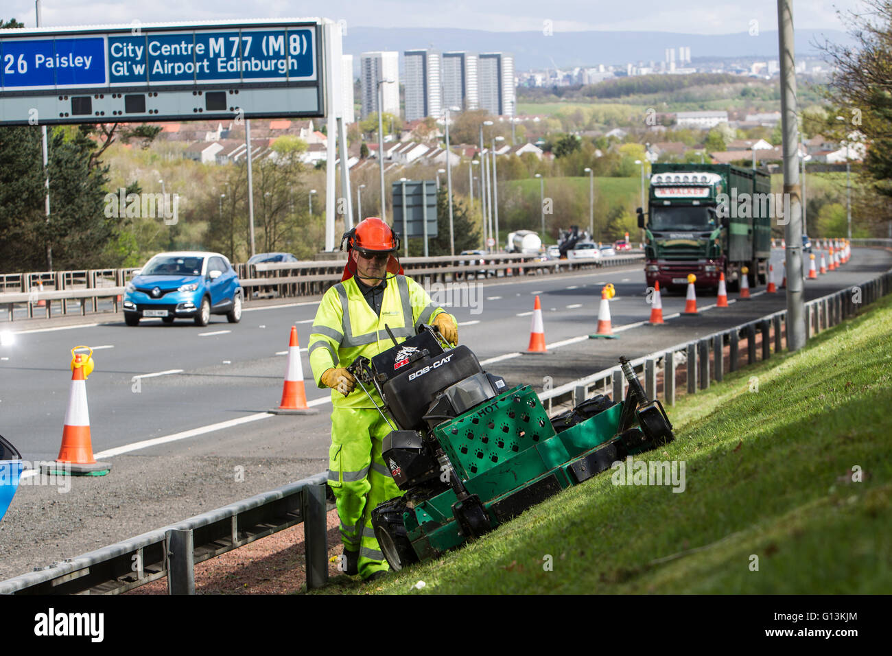 Grass cutting by busy M77 motorway Stock Photo