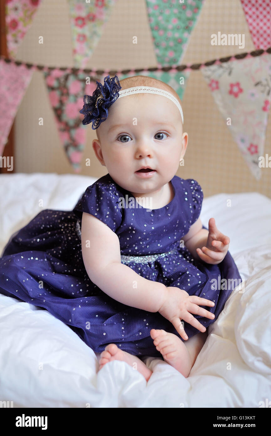 Adorable little baby girl sitting on the floor studio shot lovely portrait Stock Photo