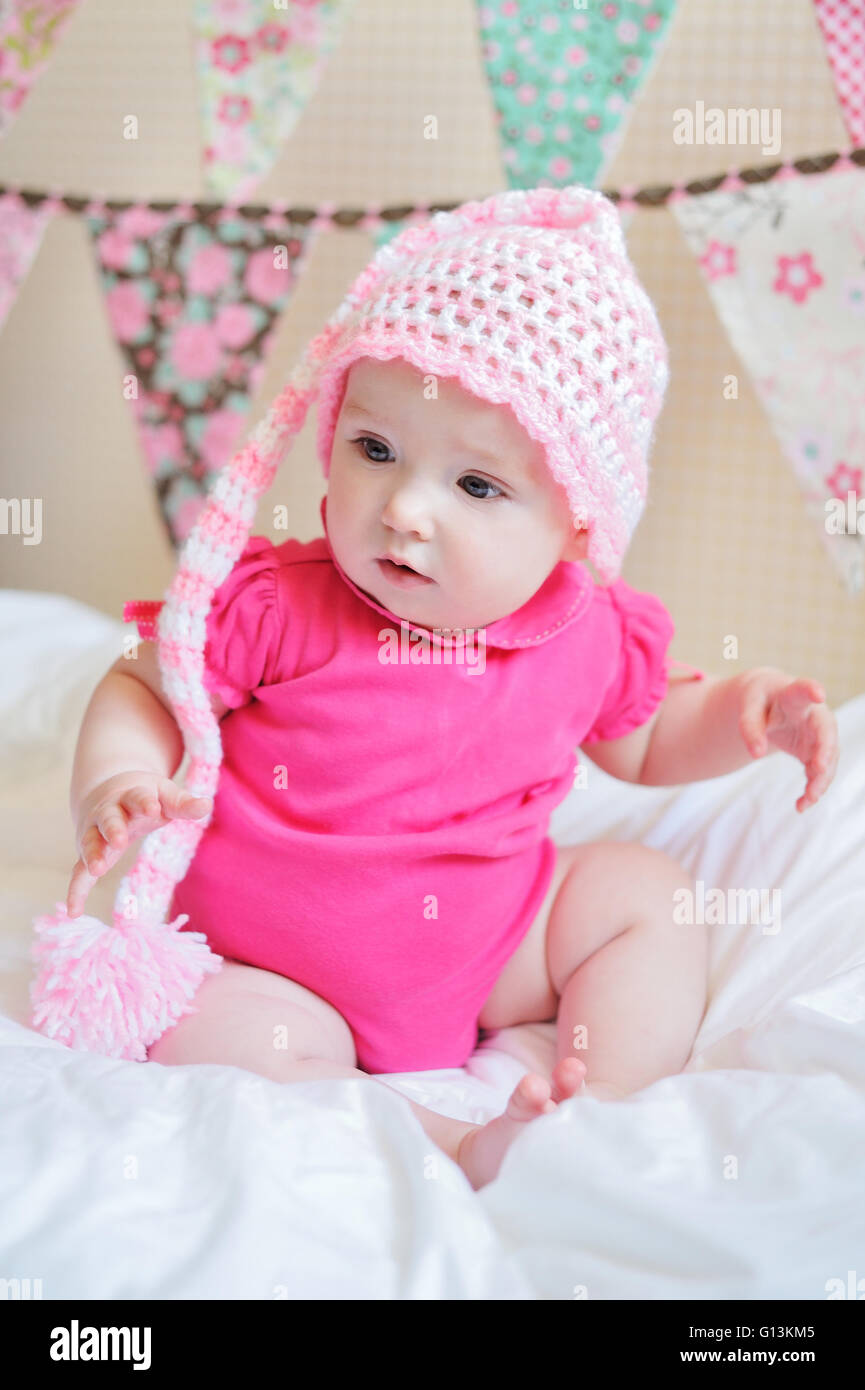 Adorable little baby girl sitting on the floor studio shot lovely portrait Stock Photo