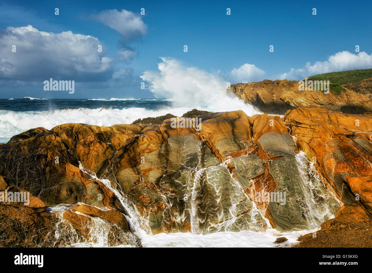 Crashing waves and high surf pound the sandstone cliffs of Point Lobos State Natural Reserve on California’s Big Sur coastline. Stock Photo