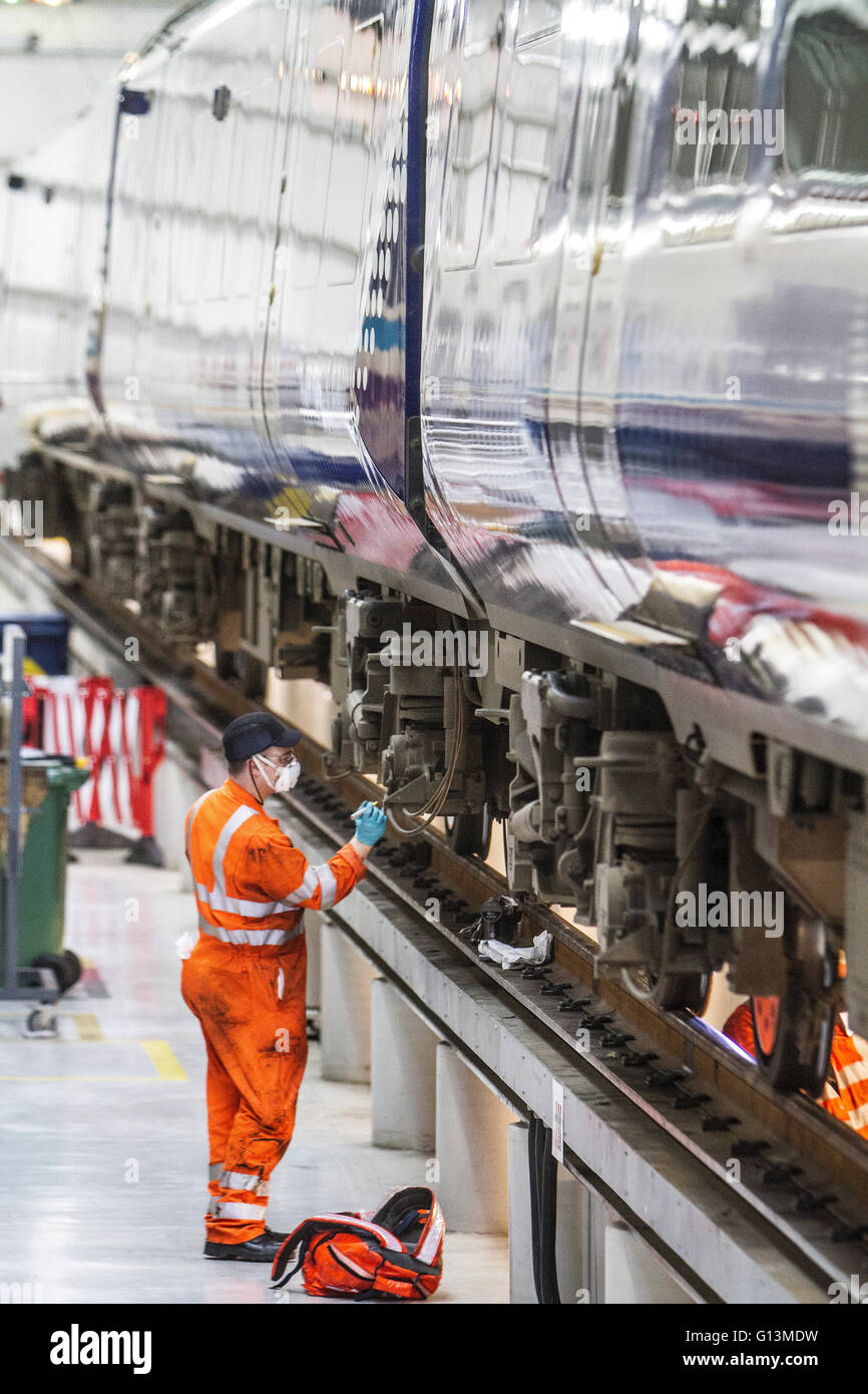Maintenance worker servicing train in depot Stock Photo