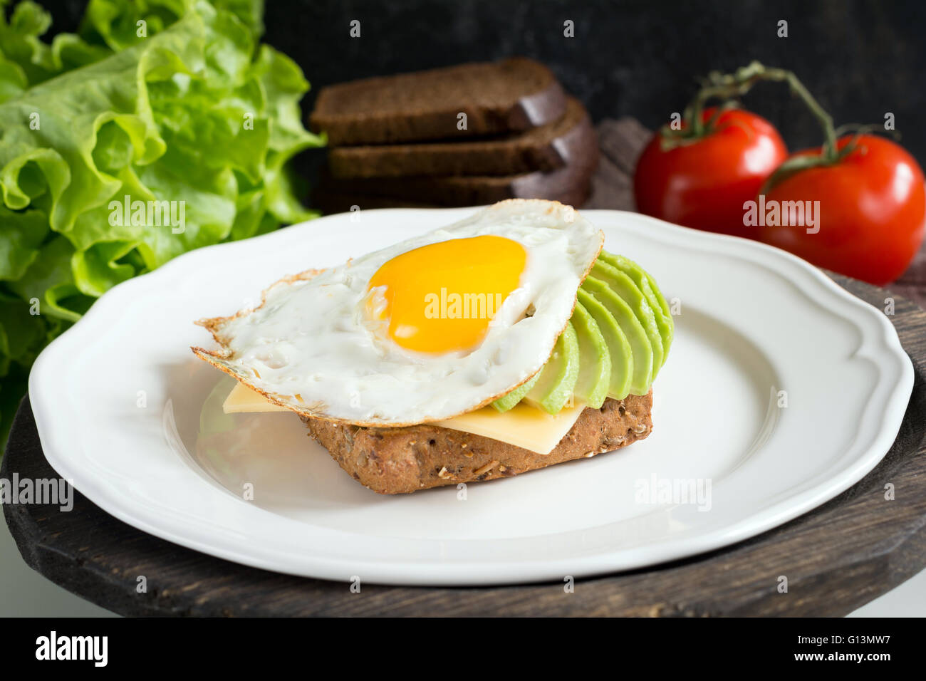 Sunny side up egg, avocado and cheese on whole grain toast for healthy