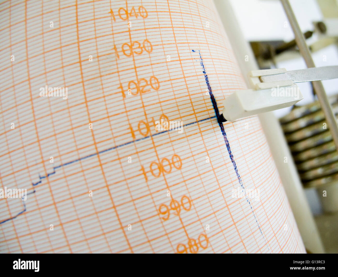 slanted far angular close-up of air pressure drum recorder with strip chart and felt pen Stock Photo