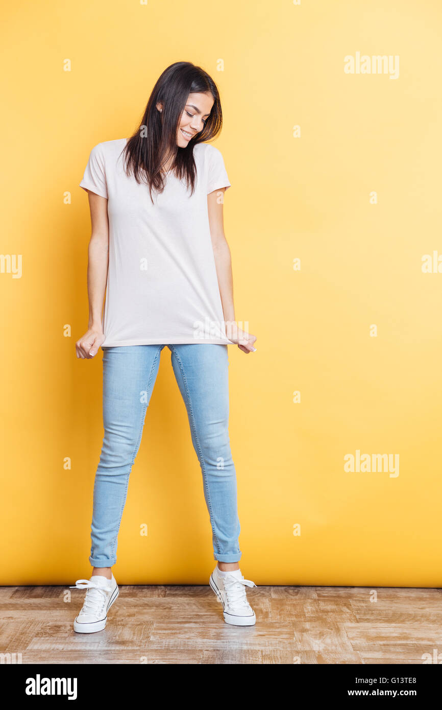 Full length portrait of a happy casual woman posing on yellow ...