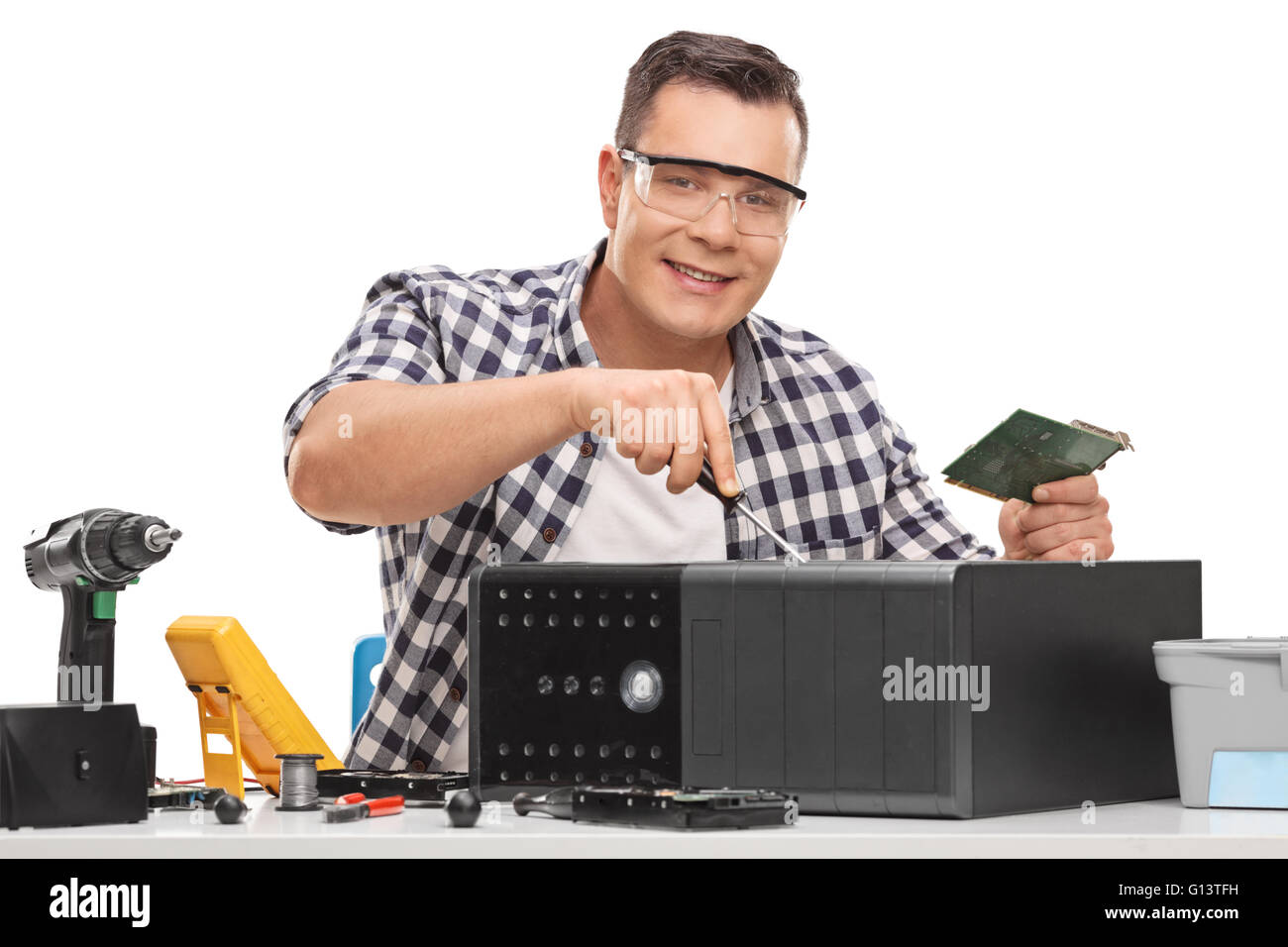 Young PC repairman fixing a broken desktop computer isolated on white background Stock Photo