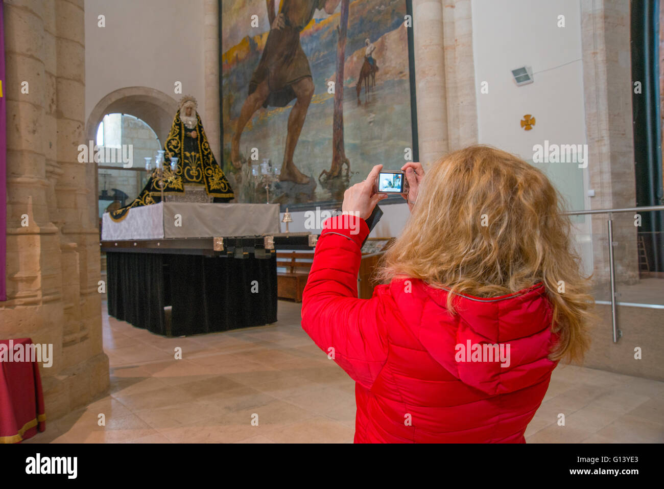 Woman taking photos of the Virgin in Holy Week. Santa Maria la Mayor church, Colmenar de Oreja, Madrid province, Spain. Stock Photo