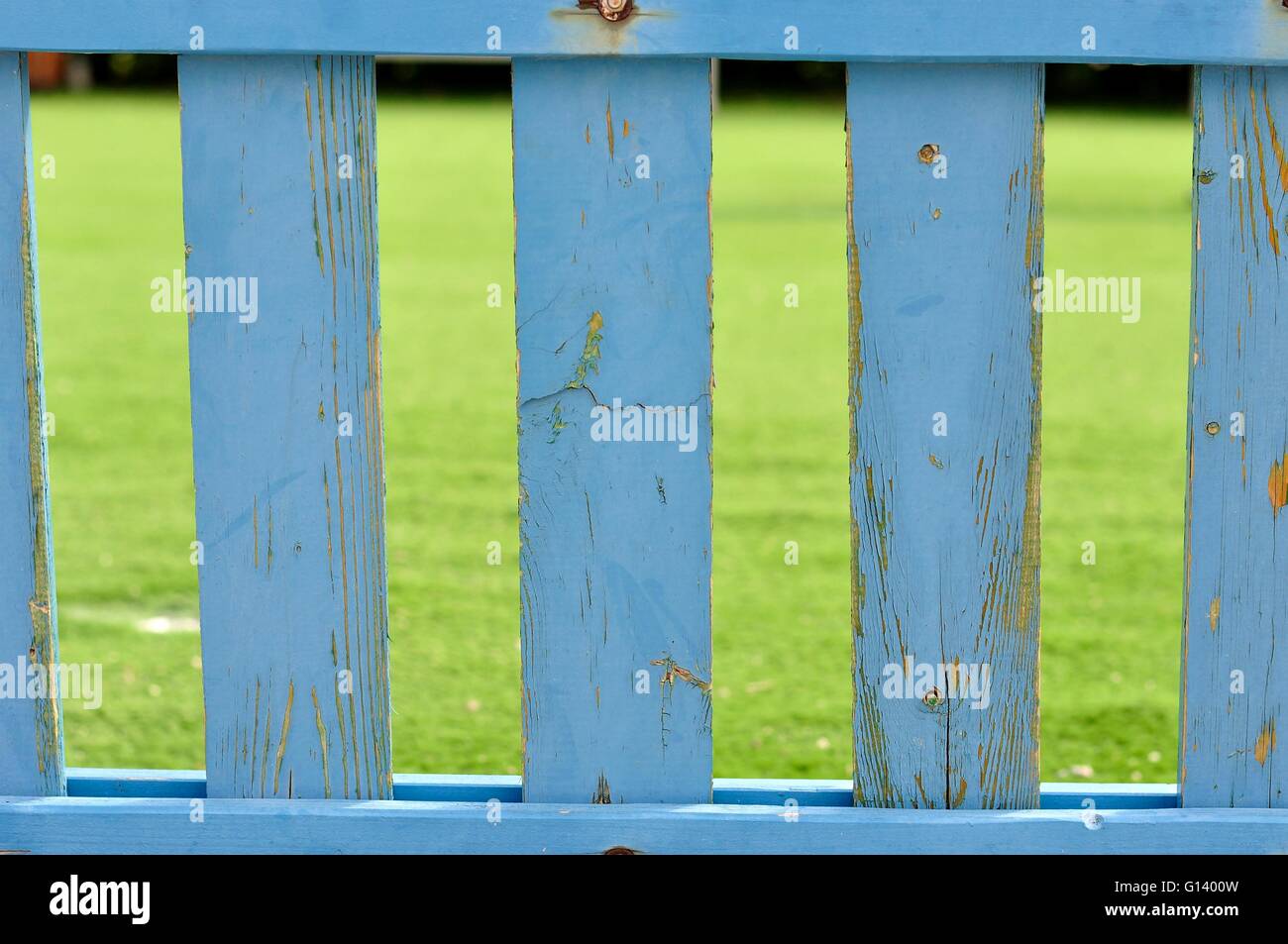 Blue wooden picket fence with blurred green background Stock Photo - Alamy