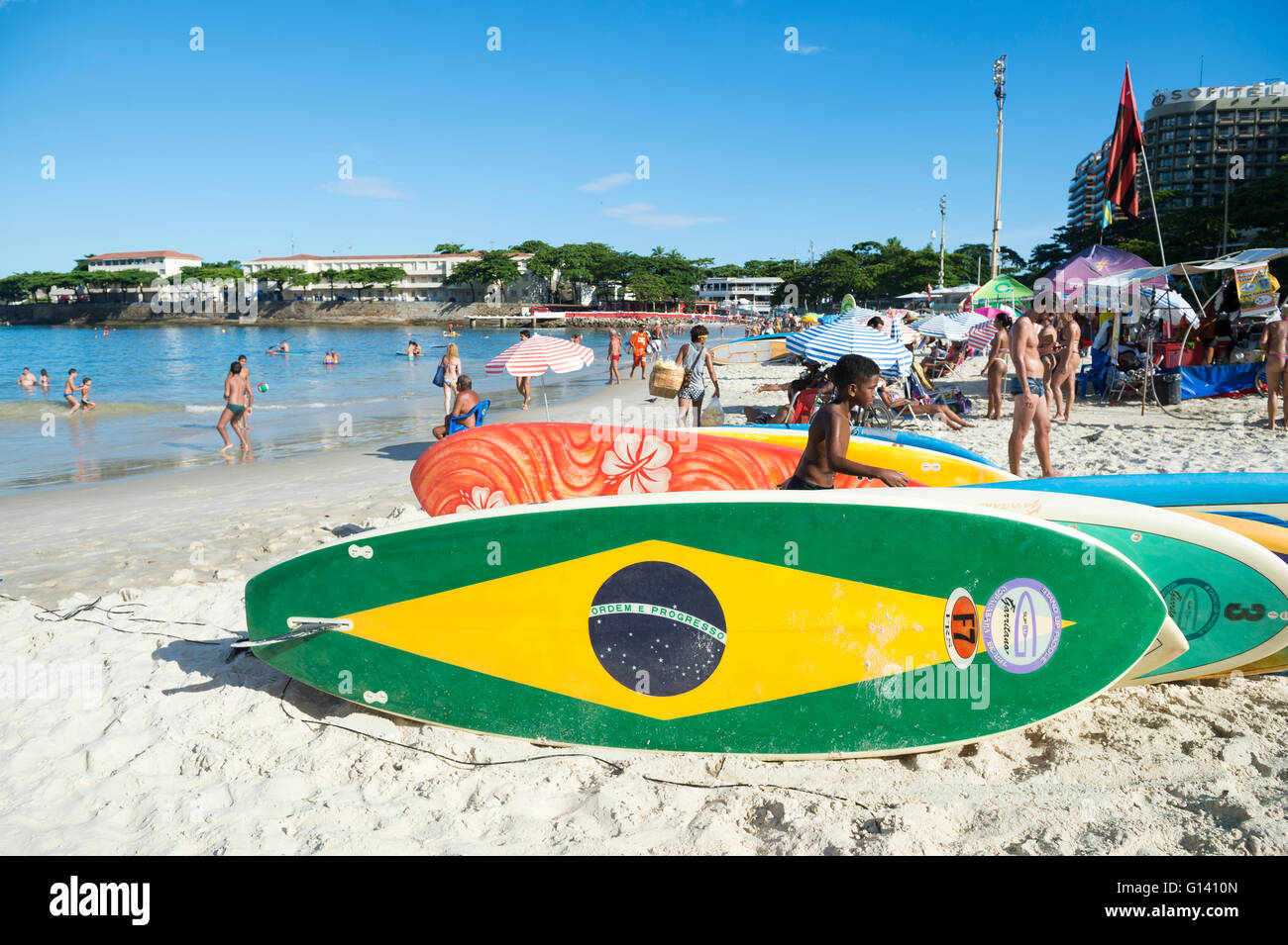 RIO DE JANEIRO - APRIL 5, 2016: Brazil flag stand up paddle surfboard waits for customers on Copacabana Beach. Stock Photo