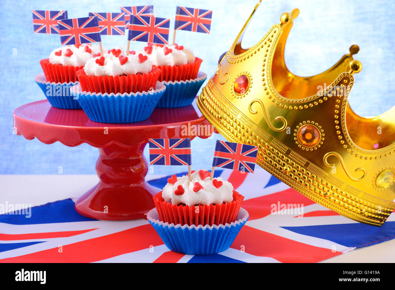 Holiday party cupcakes with UK flags on red cake stand with Union Jack flag. Stock Photo
