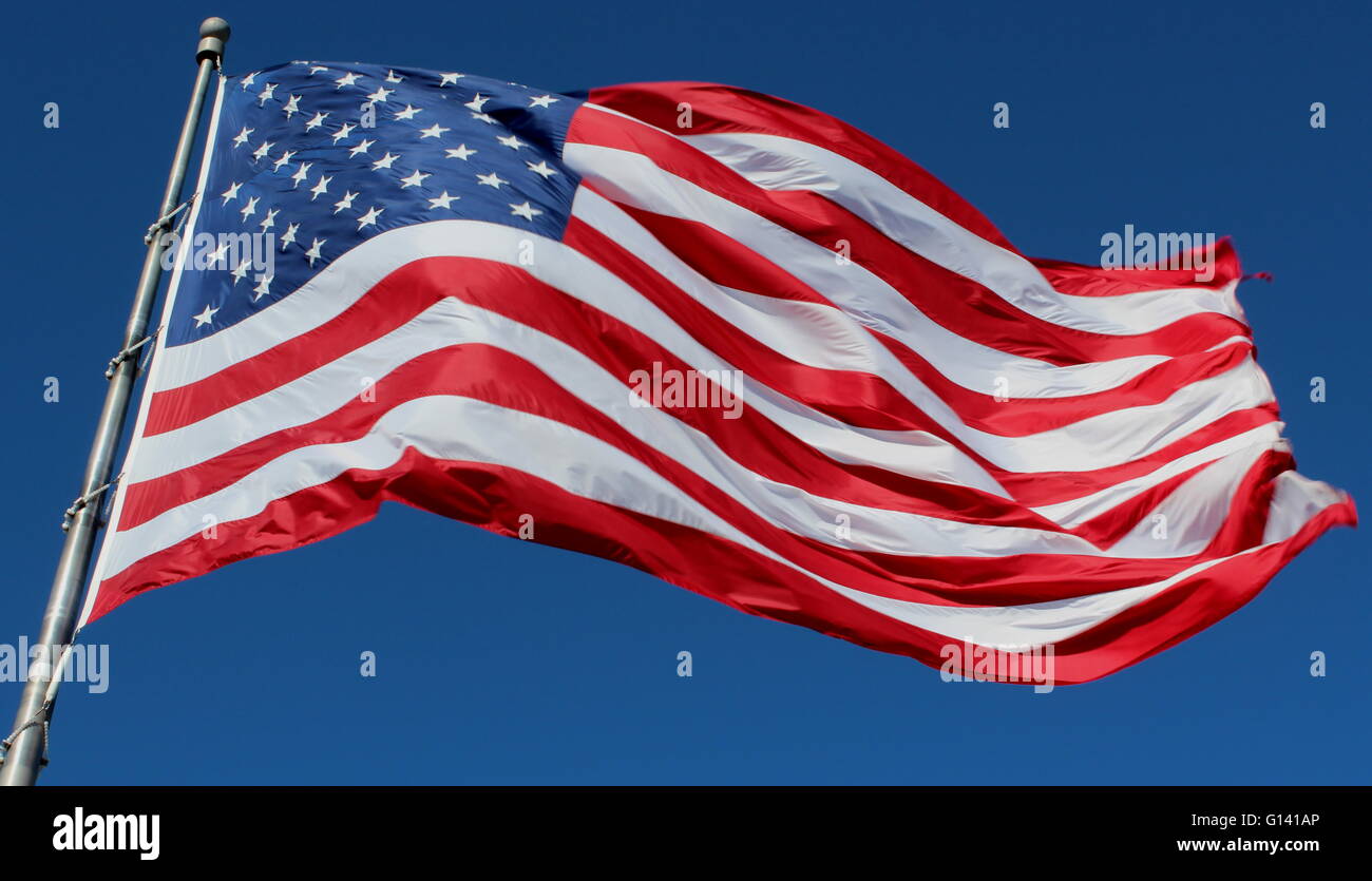 American flag flying on a blue sky background Stock Photo - Alamy