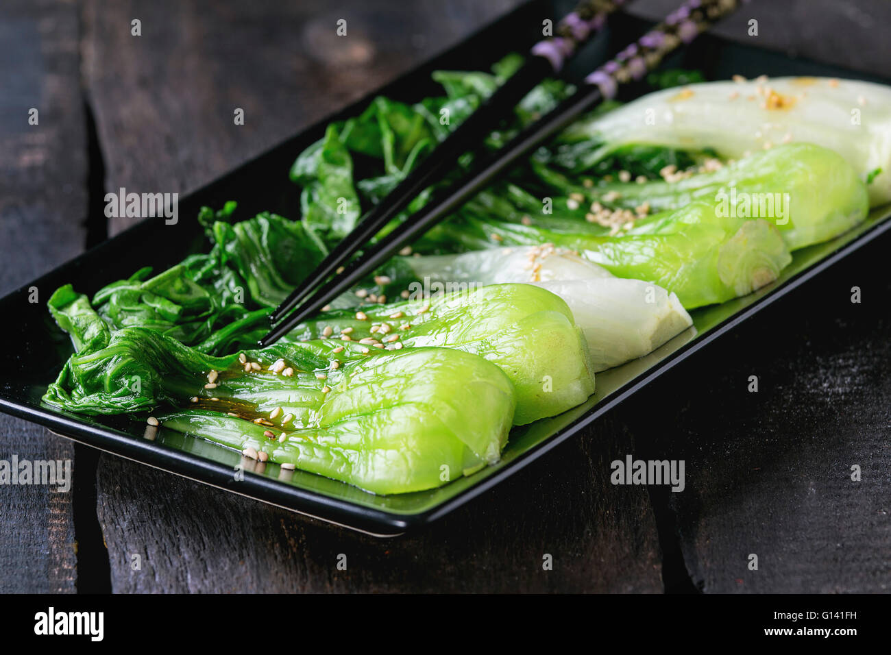 Cooked bok choy with sesame seeds and chili pepper olive oil in black