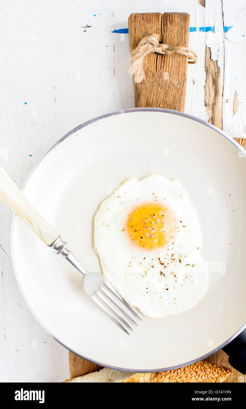 https://c8.alamy.com/comp/G141HN/fried-egg-with-spice-and-bread-slices-in-white-ceramic-frying-pan-G141HN.jpg