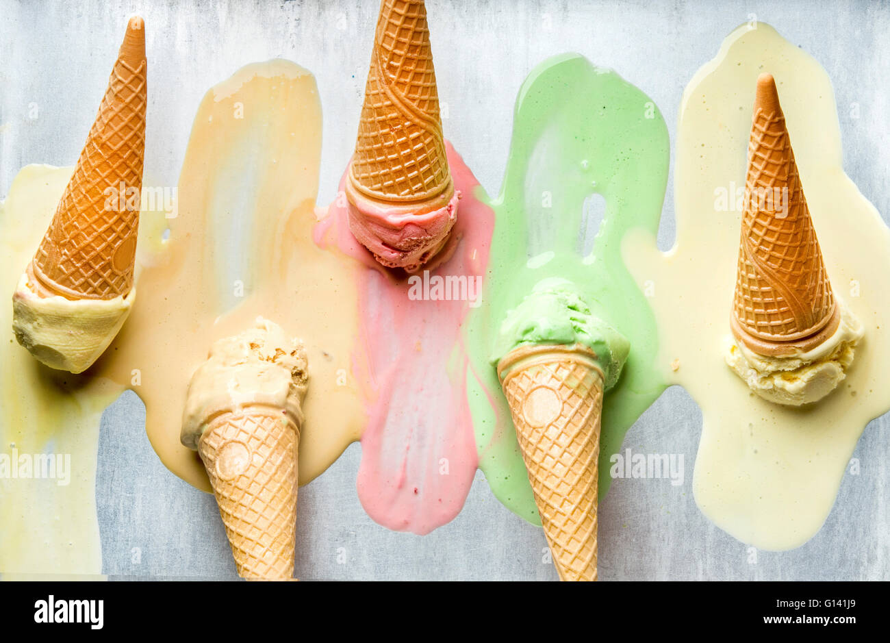 Colorful ice cream cones of different flavors. Melting scoops. Top view, steel metal background Stock Photo