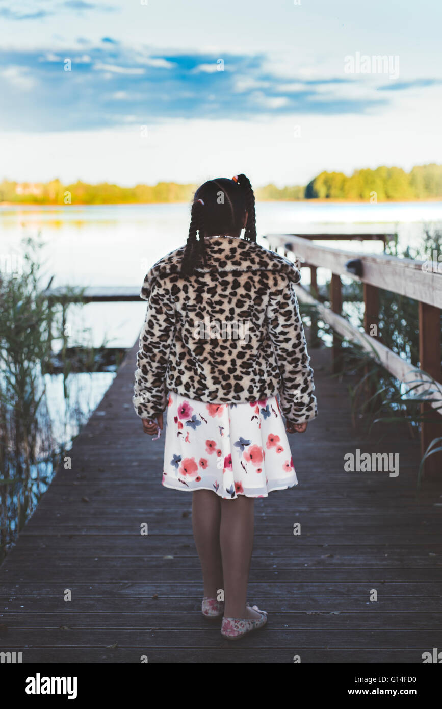 Girl is walking on the wooden pier by the lake Stock Photo - Alamy