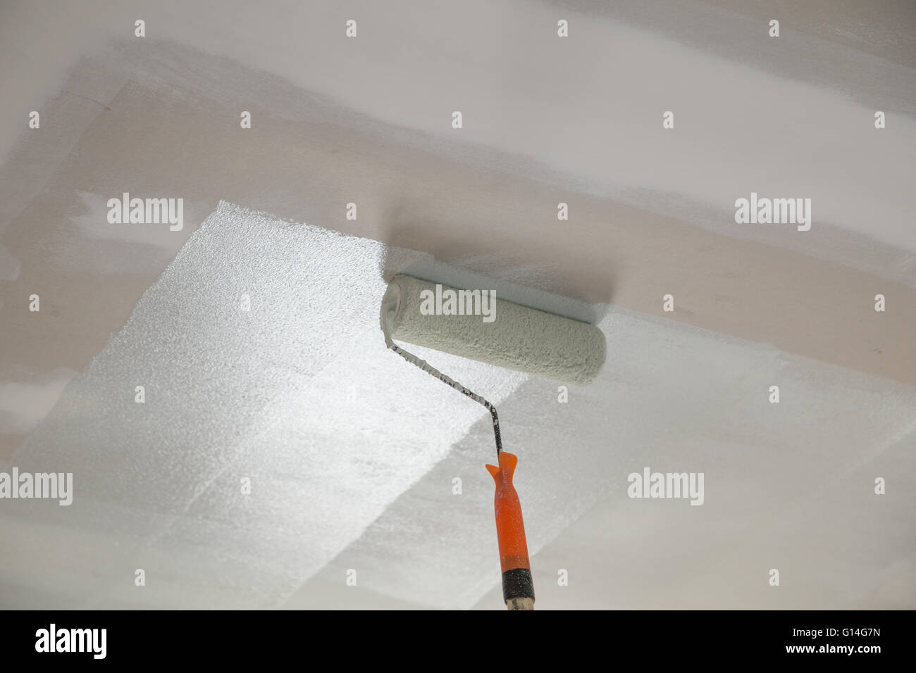 Painting A Gypsum Plaster Ceiling With Painting Roller Stock Photo